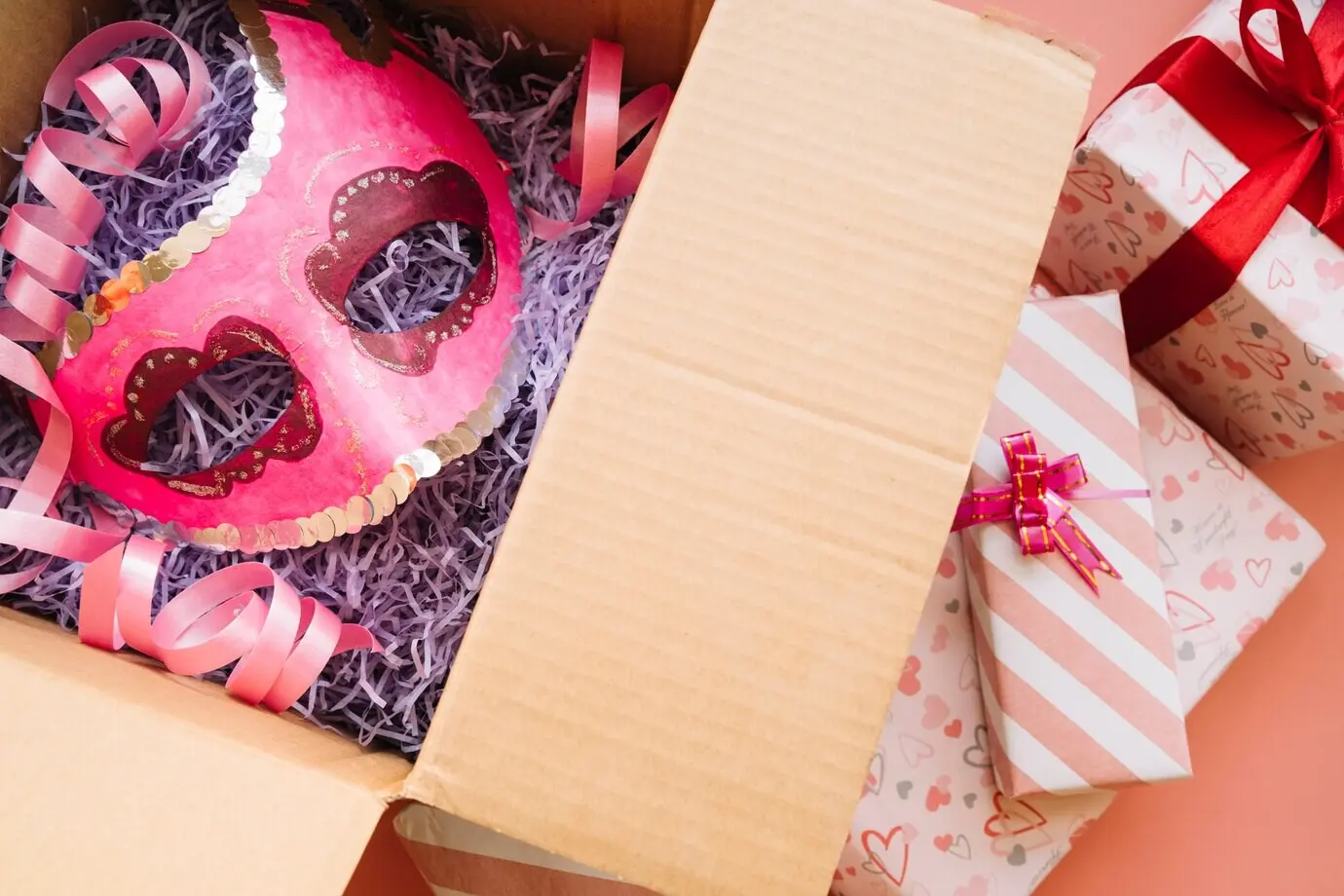 Маска, помещённая в крафтовую коробку рядом с подарками.